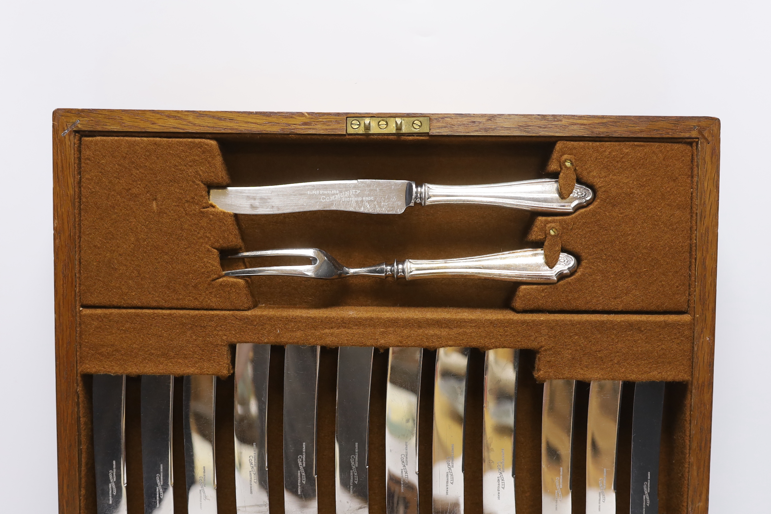An oak cased canteen containing Sheffield ‘Super stainless’ flatware and a pair of plated candelabra, 46cm